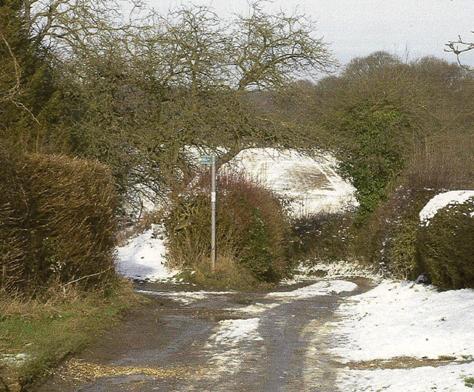 Crossing public footpaths, to left and right, whilst the Lane heads 	north-eastwards into the valley